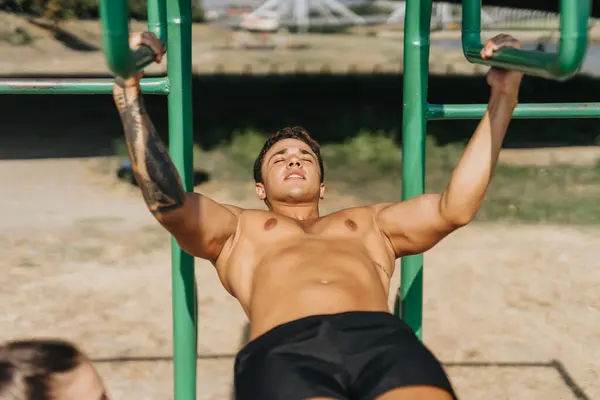 stock image Man practices outdoor workout in park. Fit bodies, stretching limbs, warming up, and training in natural environment. Happy and motivated embracing healthy lifestyle and positive results.