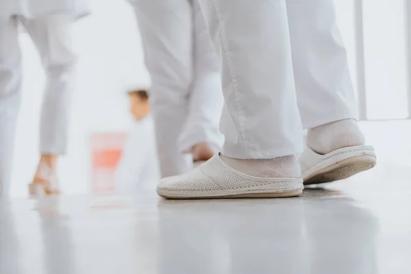 Médico Experimentado Caminando Pasillo Clínica Vistiendo Uniforme Médico Calzado Blanco —  Fotos de Stock