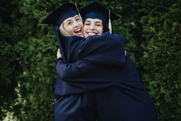 Female College Students Graduation Attire Celebrate Outdoors Hugging Sharing Positive — Stock Photo, Image