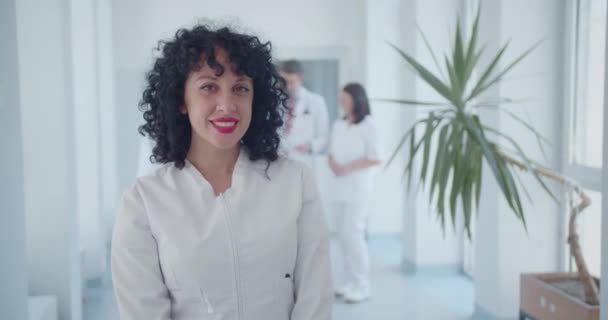 Młoda Kręcone Włosy Kobieta Lekarz Pozowanie Sali Kliniki Specjaliści Płci — Wideo stockowe