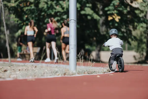 小孩在公园的赛马场骑自行车 这孩子骑自行车时开始偏离轨道 孩子们在阳光灿烂的日子里学习如何在公园里骑自行车 — 图库照片