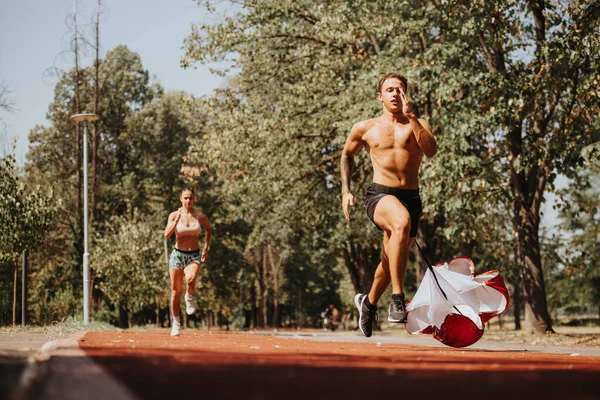 屋外でトレーニングするアスリートにフィットします 公園で走っていると 体を限界まで押し上げます 動機付けられ 彼らはよりよいボディ形および肯定的な結果に向かって働きます — ストック写真