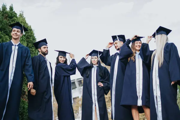 Diverse University Students Graduation Attire Celebrate Achievement Smiling Sunny Park — Stock Photo, Image