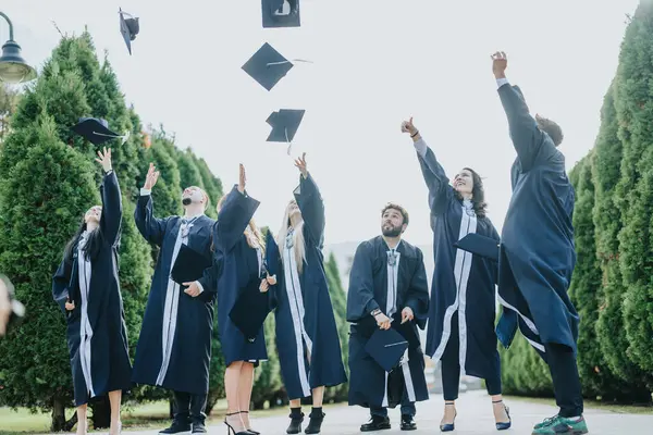 Graduates in gowns and caps celebrate achievements, create memories. Congratulating each other, having conversations. Teamwork and success evident as they walk together.