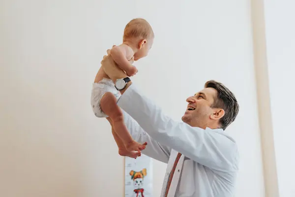 Šťastný Mužský Doktorský Pediatr Zvedající Malé Dítě Klinice Usmívají — Stock fotografie