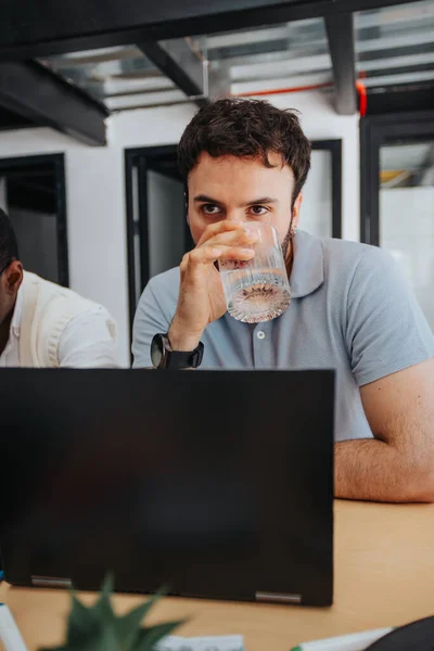 Cansado Deshidratado Empleado Masculino Bebiendo Agua Mirando Algo Oficina —  Fotos de Stock