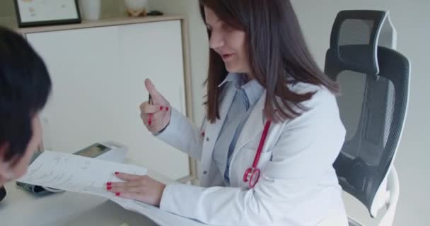 Eine Ärztin Liest Und Diskutiert Mit Ihrer Älteren Patientin Die — Stockvideo