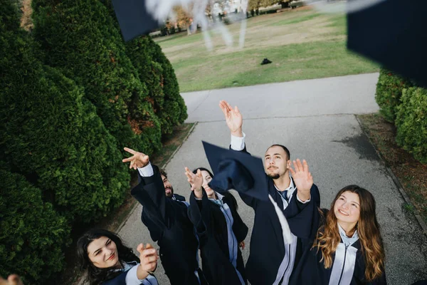 Graduated Students Caps Gowns Celebrating Graduation Park Throwing Caps Air — Stock Photo, Image