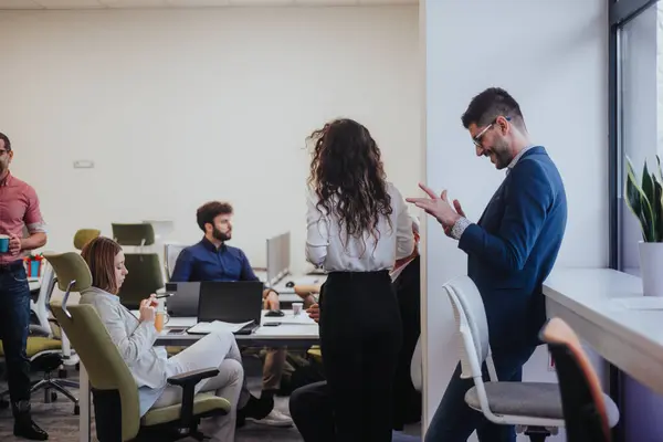 Diverse professionals collaborate in a modern office, discussing strategies for company growth and sales. Efficient teamwork and technology drive success.