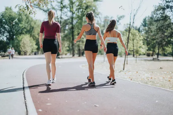 Drie Fitte Vrouwen Atletische Kleding Joggen Een Racebaan Een Stadspark — Stockfoto