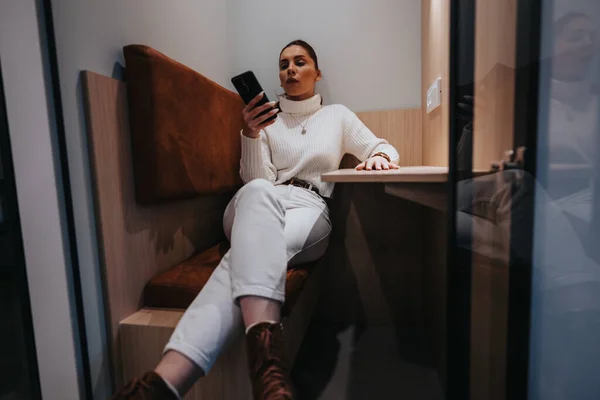 stock image Gorgeous female taking a break from work while having video call meeting sitting in soundproof phone booth.