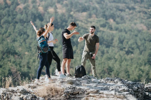 Young, athletic group hiking in lush forest, enjoying natures beauty. Friends having fun, exploring outdoors, engaged in conversation. Healthy, active lifestyle amidst scenic mountain landscape.