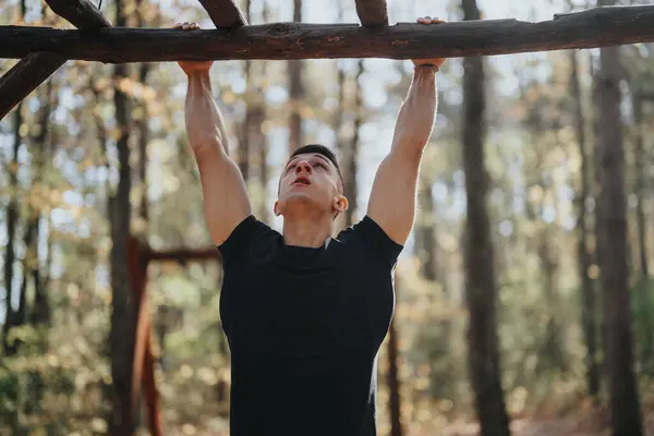 A happy hiker enjoys an active day in nature, doing pull ups outdoors in a beautiful forest. Embrace adventure and explore the green environment during a sunny weekend.