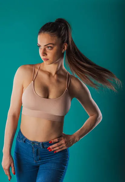 Selbstbewusstes Weibliches Fitnessmodel Posiert Mit Muskulösem Körper Auf Türkisfarbenem Hintergrund — Stockfoto