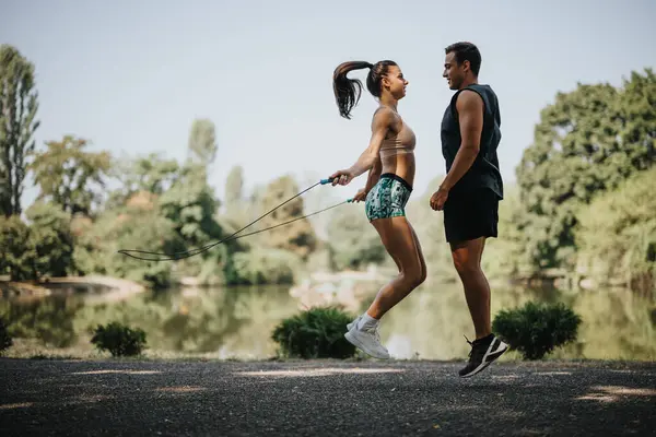 Caucasian Couple Sportswear Jumping Rope Outdoors Sunny Park Reflecting Positive — Stock Photo, Image
