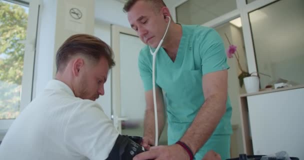 Опытный Врач Измеряющий Дыхание Давление Своего Молодого Пациента — стоковое видео