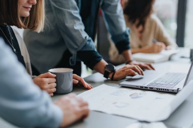 Close up photo of coworkers collaborating in a creative office, discussing reports, and strategizing for business growth. clipart