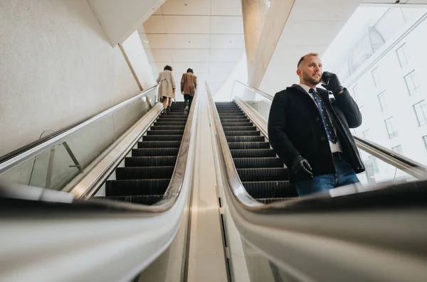 Hombre Profesional Abrigo Usando Teléfono Escaleras Mecánicas Entorno Urbano Moderno — Foto de Stock