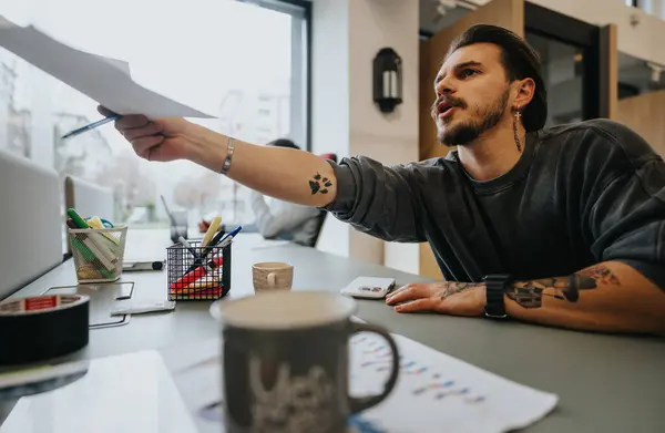 Odaklanmış Dövmeli Adam Modern Ofis Ortamında Proje Fikirlerini Tartışıyor — Stok fotoğraf