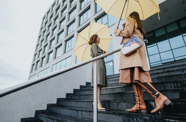 Elegantní Ženy Držící Žluté Deštníky Přátelskou Konverzaci Schodech Před Moderní — Stock fotografie