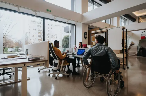 Modern Office Setting Showcasing Diversity Man Wheelchair Multiethnic Colleagues Working — Stock Photo, Image