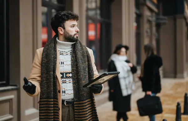 时尚的年轻人 留着胡子 穿着冬衣 在繁华的城市街道上使用数码平板电脑 彰显了城市的生活方式和连通性 — 图库照片