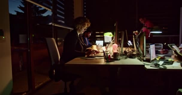 一组专心致志的人在灯光昏暗的办公室里专心工作 在深夜为一个项目进行协作 这反映了他们对共同目标的承诺和决心 — 图库视频影像