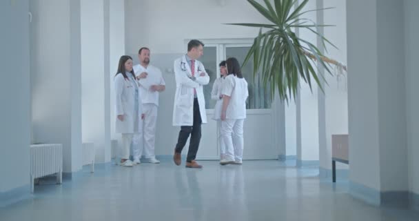 Equipo Especialistas Médicos Conversando Moderno Vestíbulo Iluminado Por Sol — Vídeo de stock