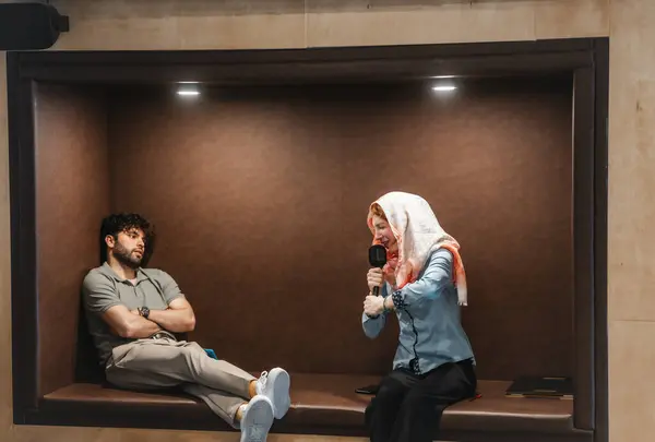 Vibrant Woman Hijab Sings Karaoke Enthusiasm While Casually Seated Man — Stock Photo, Image
