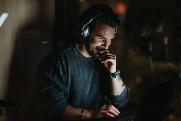 Joyful Bearded Man Wearing Headphones Smiling While Looking Laptop Screen — Stock Photo, Image