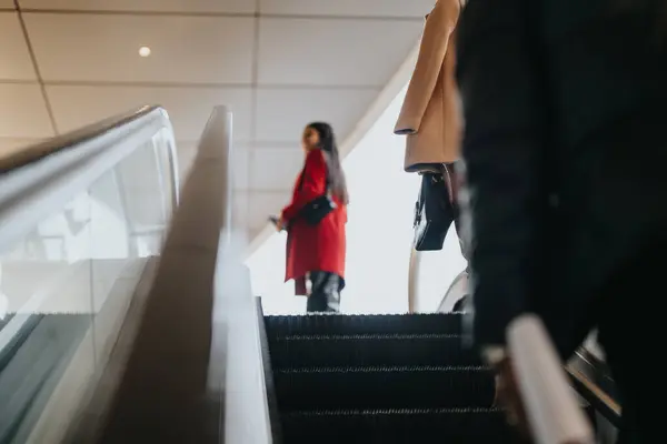 Elegant Businesswoman Red Coat Followed Colleague Escalator Ascending Contemporary Corporate — Stock Photo, Image