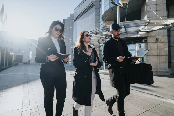 3名年轻企业家在外面散步时参与了一场商业讨论 以建筑物为背景 体现了团队精神和协作精神 — 图库照片