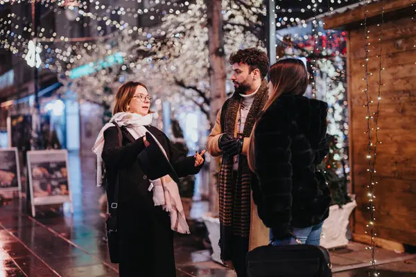 Young Adults Engaging Conversation Winter Night Surrounded Twinkling Christmas Lights — Stock Photo, Image