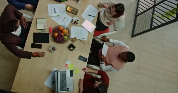 Egy Vegyes Fajú Csoport Egy Modern Irodaasztalnál Tárgyal Laptopokkal Dokumentumokkal — Stock videók