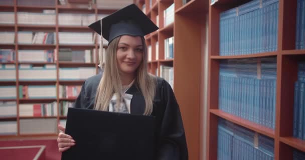 Laureata Studentessa Orgogliosamente Elevando Suo Diploma Presso Sala Biblioteca Universitaria — Video Stock