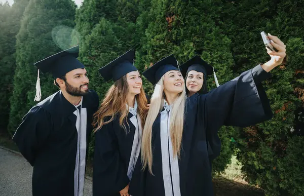 Mezuniyet Şapkalı Cüppeli Mutlu Öğrenciler Başarılarını Kutluyor Selfie Çekiyor Arkadaşlarıyla — Stok fotoğraf