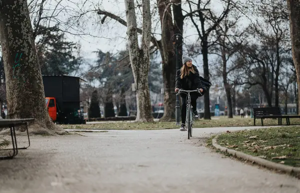 年轻女子在宁静的公园里悠闲自在地骑自行车 — 图库照片