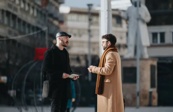 两个时髦的年轻人在城市街道上聊天 — 图库照片