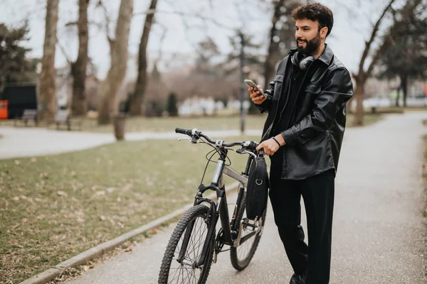 自転車のスマートな服装の男性ビジネス起業家がリラックスした屋外環境で携帯電話をチェックしています — ストック写真