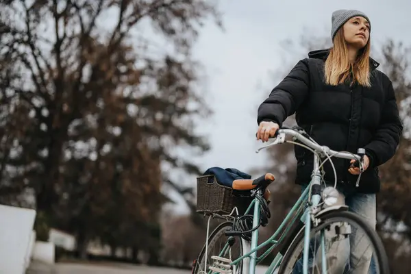 年轻女子骑着自行车在城市公园里散步 — 图库照片
