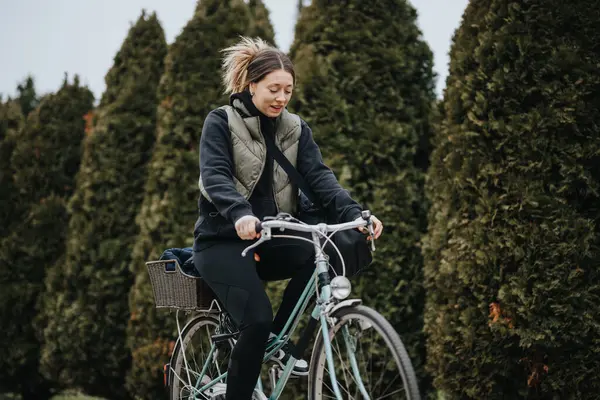 一位快乐的年轻女骑手 在清静的公园里 在茂密的绿叶中微笑着骑着自行车 唤起了自由和健康的生活方式 — 图库照片