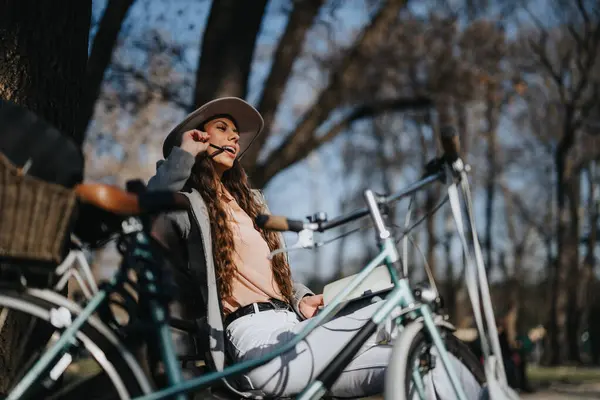 时尚的年轻女子骑自行车在公园里享受着阳光灿烂的一天 — 图库照片