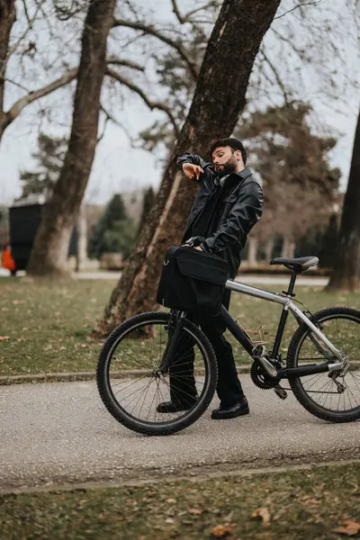 Deri Ceketli Bir Girişimci Bisiklete Yaslanmış Dışarıdaki Bir Yerde Saatini — Stok fotoğraf