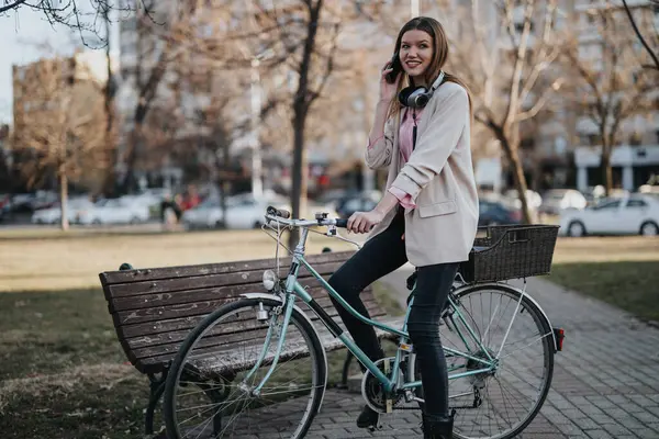 Улыбающаяся Молодая Женщина Разговаривает Мобильному Телефону Опираясь Свой Винтажный Велосипед — стоковое фото