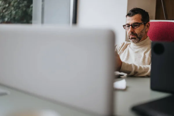 Hombre Concentrado Mediana Edad Con Gafas Trabajando Diligentemente Ordenador Espacio —  Fotos de Stock