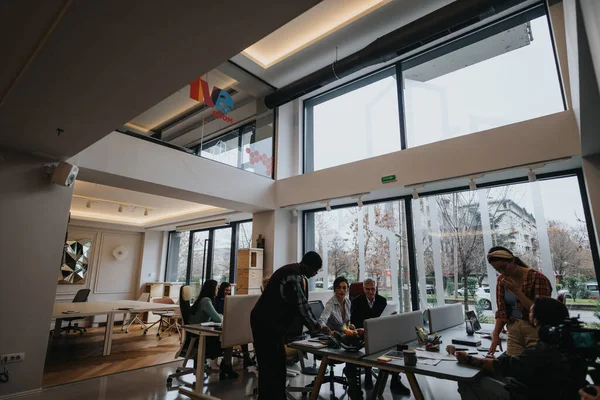 広大な窓とクリエイティブな雰囲気の明るく現代的なオフィススペースで協力する多文化グループ — ストック写真