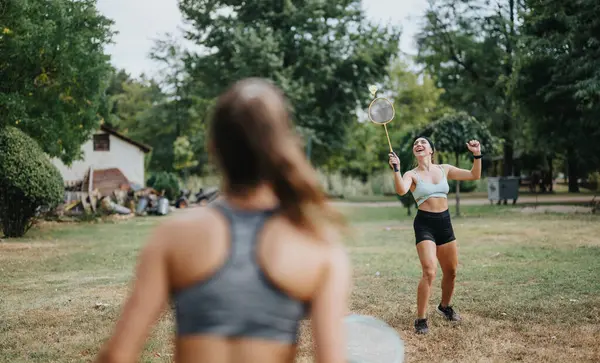 朋友们在公园打羽毛球 享受阳光灿烂的一天 健美的年轻女性在户外玩乐 展示健康的生活方式 — 图库照片