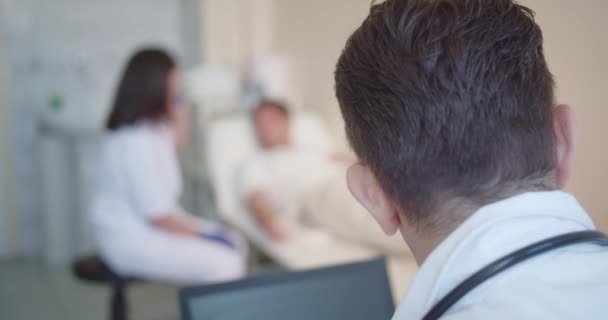 Опытный Врач Дает Инструкции Своему Медицинскому Ассистенту Делать Терапией Отношении — стоковое видео