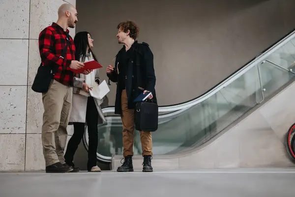 Three Professionals Engaged Conversation While Standing Escalator Possibly Discussing Work — Stock Photo, Image
