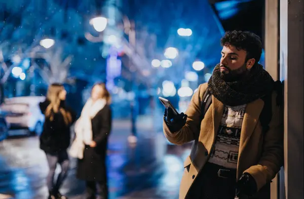 Άνθρωπος Ελέγχει Τηλέφωνο Νύχτα Στο Δρόμο Της Πόλης Θολή Ανθρώπους — Φωτογραφία Αρχείου